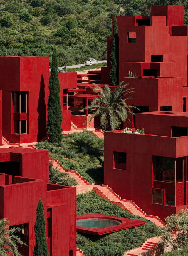 Volumes géométriques rouges et jardins en terrasses du concept architectural Red Sol Resort